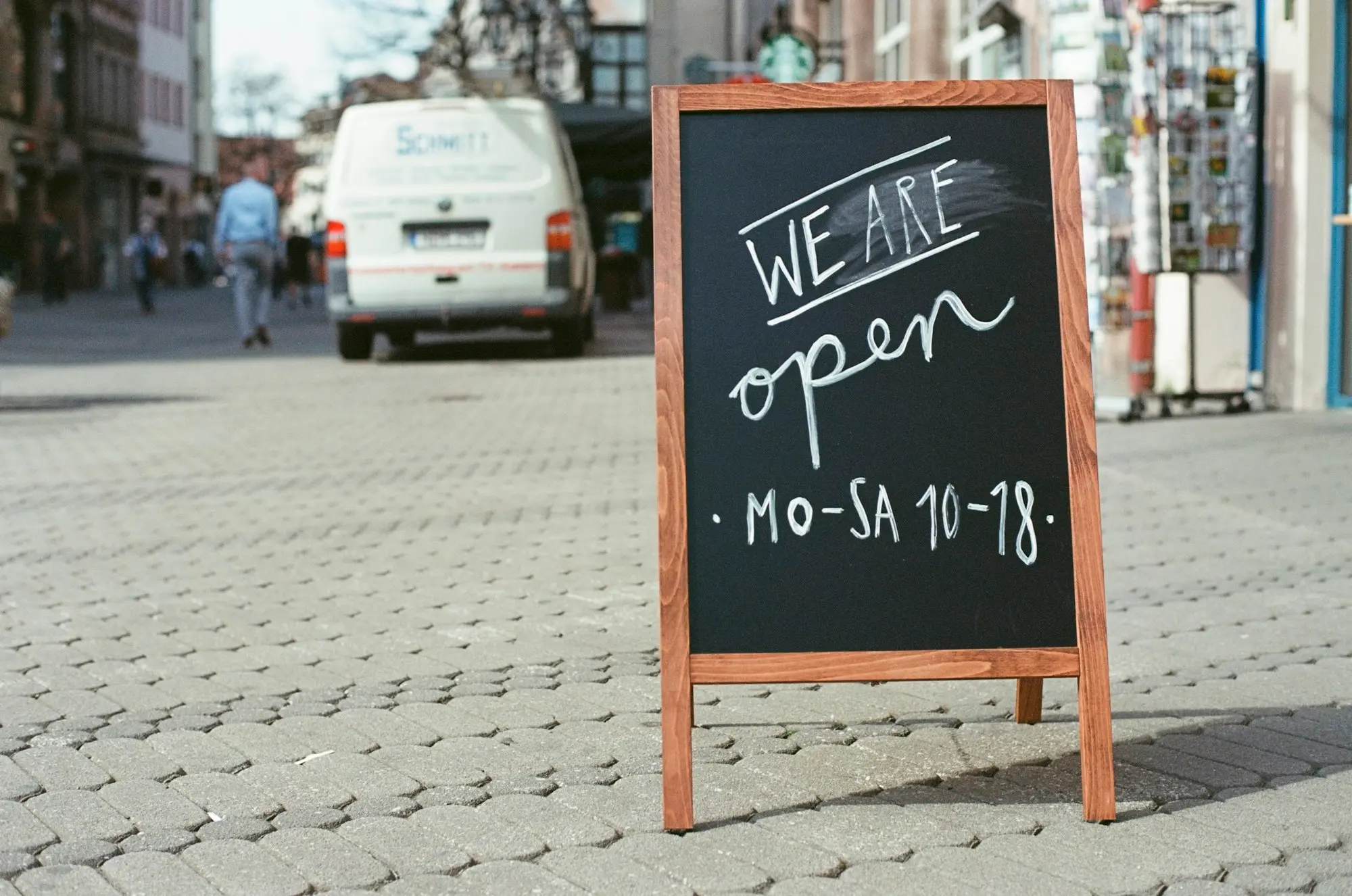 Chalkboard sign saying the shop is open